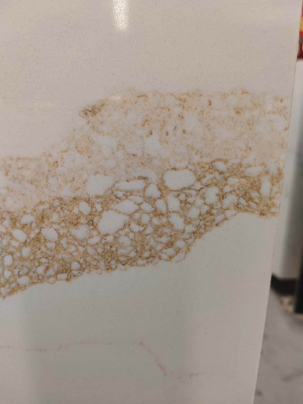 Aoli Stone quartz slab installed in a modern kitchen interior White quartz slab with gold veining used for a kitchen island project in the Middle East