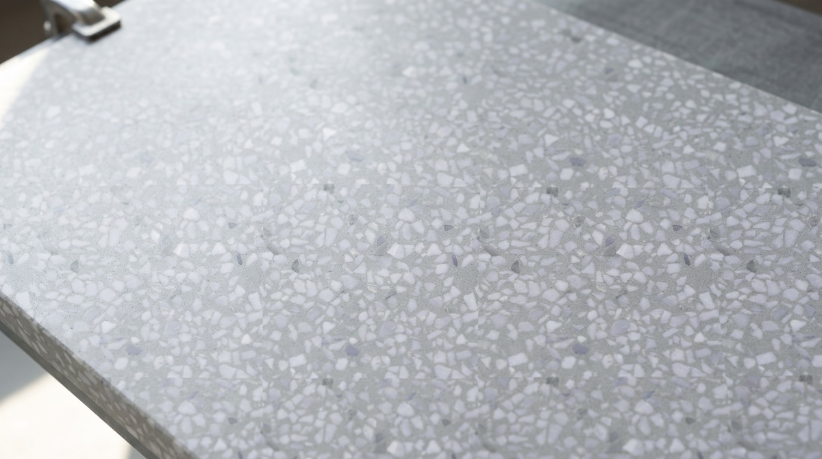 grey-terrazzo-countertop-surface-close-up Close-up view of grey terrazzo countertop surface with white marble chips and smooth polished finish.