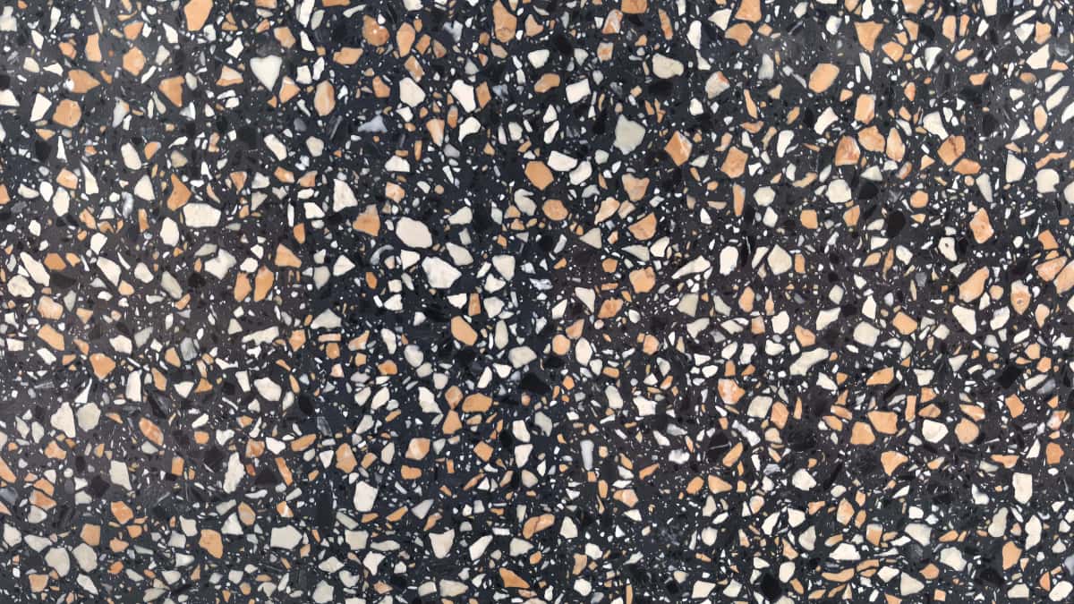 amber-night-black-terrazzo-white-amber-chips-closeup •Close-up of Amber Night terrazzo with charcoal matrix and irregular white grey and amber chips