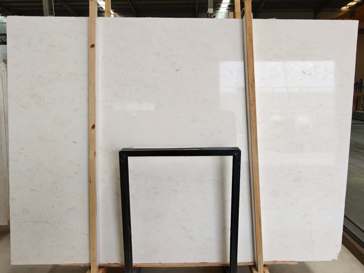 moon-beige-limestone-full-slab Full Moon Beige limestone slab showing a warm light beige background and natural fossil variation