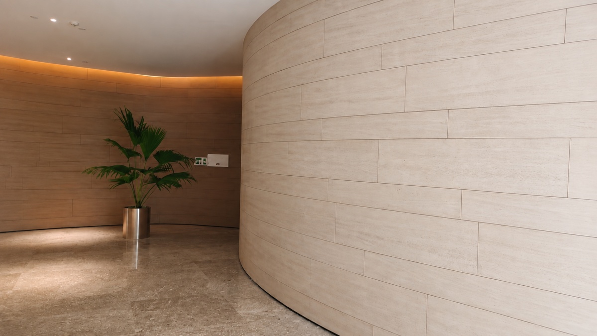 ivory-wood-grain-limestone-curved-wall Light ivory wood grain limestone panels installed on a straight hospitality wall